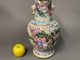 un vase orné d'un dragon, à côté d'une pomme