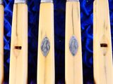 Plusieurs stylos sont alignés en rang sur un tissu bleu