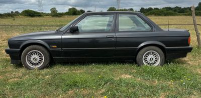 une voiture noire garée dans l'herbe