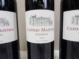 three bottles of red wine are lined up on a table