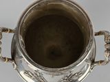 an antique silver cup with handles and handles on a stand