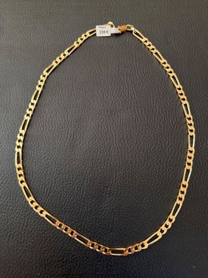 a gold chain necklace on a black surface