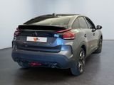 the rear end of a silver car in a room with white walls