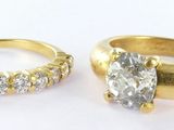 deux bagues en or serties de diamants et une bague posée sur un fond blanc