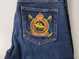 la poche arrière d'un jean sur laquelle est épinglé un insigne