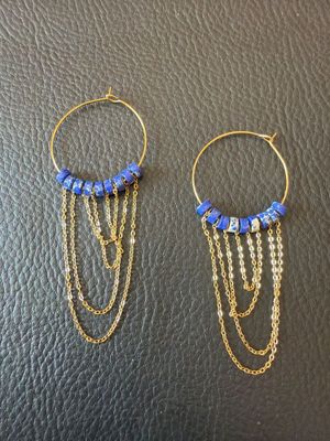 une paire de boucles d'oreilles avec des perles bleues et des chaînes dorées