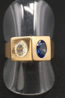 un gros plan d'une bague en or sertie de deux saphirs bleus