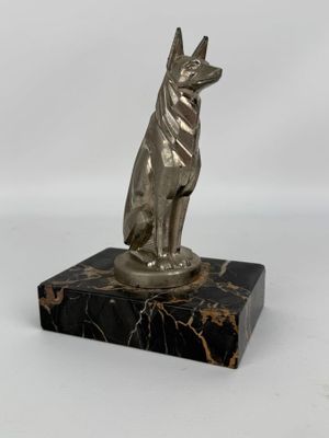 statue d'un chien assis sur un socle en marbre, sur fond blanc