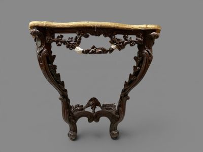 an ornately carved console table with a marble top