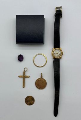 un gros plan d'une montre et d'autres objets posés sur une surface blanche