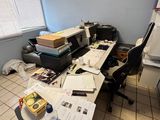 a desk with a lot of clutter and papers on it