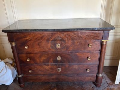 a wooden chest of drawers with a marble top