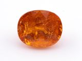 un gros plan d'un saphir orange sur une surface blanche