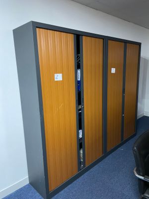 a black chair in a room with two wooden lockers