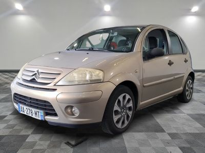 a picture of a small beige car parked in a garage