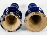 pair of blue vases sitting on top of a white surface