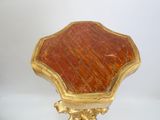 une table dorée et rouge avec un plateau en marbre