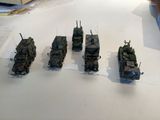 several military vehicles are lined up on a white table