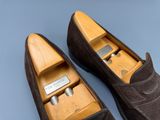 une paire de pantoufles pour homme en cuir marron, avec une boîte en bois au milieu