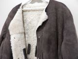 a brown jacket with a white collar on a hanger