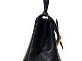 a black leather handbag with a gold handle on a white background
