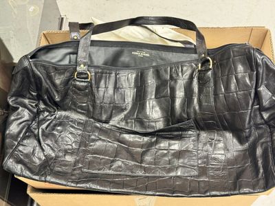 un sac à main en cuir noir posé sur une boîte en carton