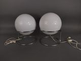 pair of white glass globe lamps with metal bases