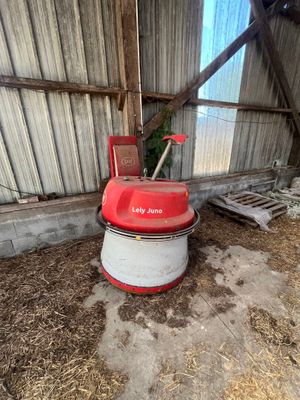 une machine rouge et blanche qui se trouve dans une grange
