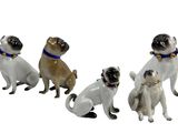 quatre figurines de chiens portant un collier et une clochette autour du cou