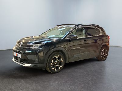 Le SUV noir est garé dans une grande pièce au sol noir.