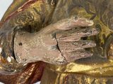 statue of a man in a golden robe holding his hands together