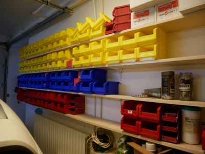 de nombreux bacs et conteneurs sur les étagères du garage