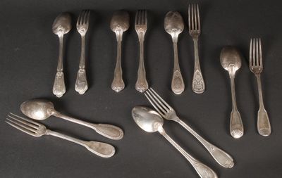 many forks and spoons laid out on a table