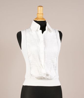 une femme vêtue d'une chemise blanche et d'une jupe noire, avec un foulard blanc autour du cou