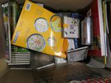 une boîte en carton remplie de livres et de papiers, posée par terre