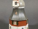 a small white and red building with a dome on top