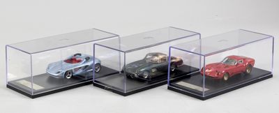 trois voitures miniatures dans une vitrine posée sur une surface blanche
