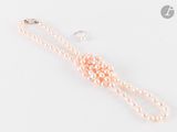 Collier et boucles d'oreilles en perles roses sur fond blanc