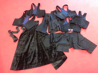 three pieces of black clothing on a red surface