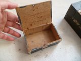 une main qui tient une petite boîte sur une table