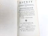 an old book that is open on a white surface
