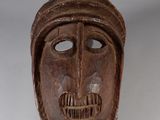 an old wooden mask on a white surface with a white background