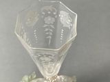 a glass vase with a flower on it sitting on a table