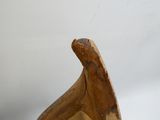 une sculpture en bois représentant un oiseau posée sur une table