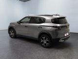 the rear view of a silver suv parked in a showroom