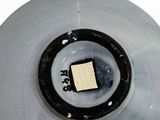 a white bowl with a black rim and a square piece of paper in the center