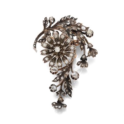 un gros plan d'une broche ornée de fleurs et de feuilles