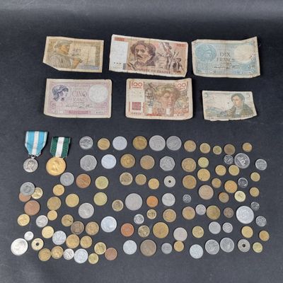 an assortment of coins and medals are displayed on a table
