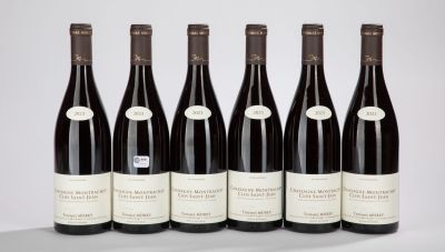 six bottles of wine are lined up in a row on a table