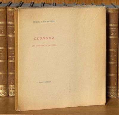 un livre posé sur une étagère où se trouvent de nombreux livres
